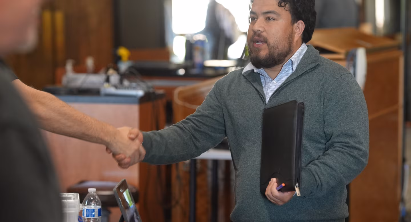 A job seeker and an employer shake hands at an INCIGHT job fair.