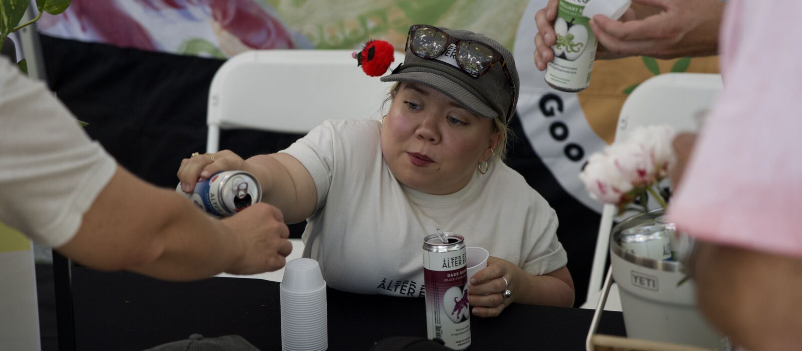 A stallholder serving customers at her own drinks stand.